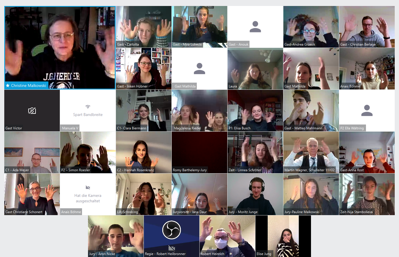 Bildschirmfoto der Videokonferenz der Veranstaltung mit Fotokacheln der Teilnehnenden, die mit den Händeln wedeln, um den Applaus zu ersetzen